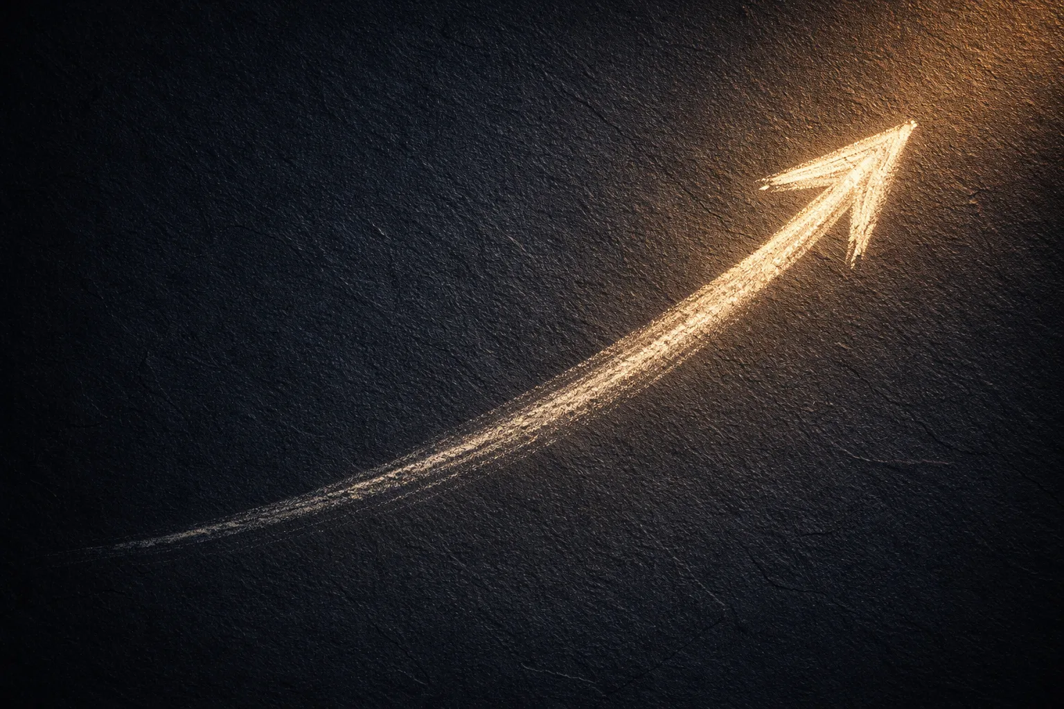 A chalk arrow on dark slate beginning as a faint thin mark and widening into a bold bright stroke as it rises to the right